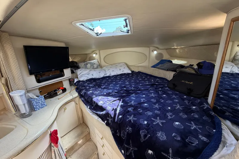 Slide: The Image of Interior cabin of 1999 Sea Ray Sundancer 310 with bed, TV, and storage. - 22