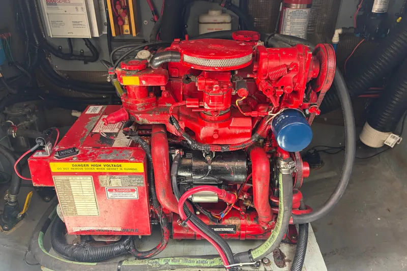 Slide: The Image of Red engine in a 1999 Sea Ray Sundancer 310 boat, featuring high voltage warning. - 38
