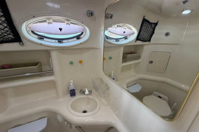 Slide: The Image of 1999 Sea Ray Sundancer 310 bathroom with sink, mirror, and porthole windows. - 30
