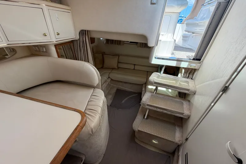 Slide: The Image of Interior of 1999 Sea Ray Sundancer 310 yacht, featuring cozy seating and carpeted steps. - 32