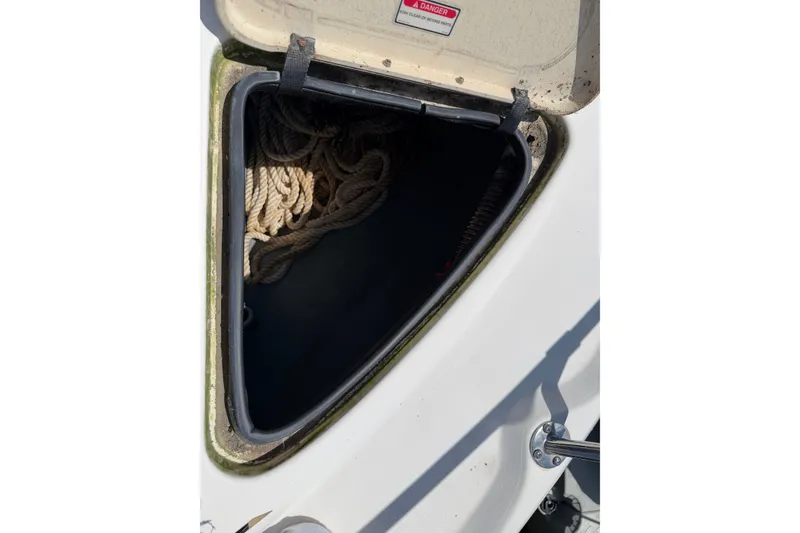 Slide: The Image of Open storage compartment on 1999 Sea Ray Sundancer 310 boat, containing coiled rope. - 36