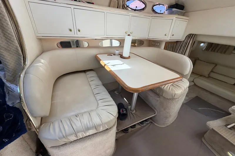 Slide: The Image of Interior of a 1999 Sea Ray Sundancer 310 with a cozy dining area and storage cabinets. - 25