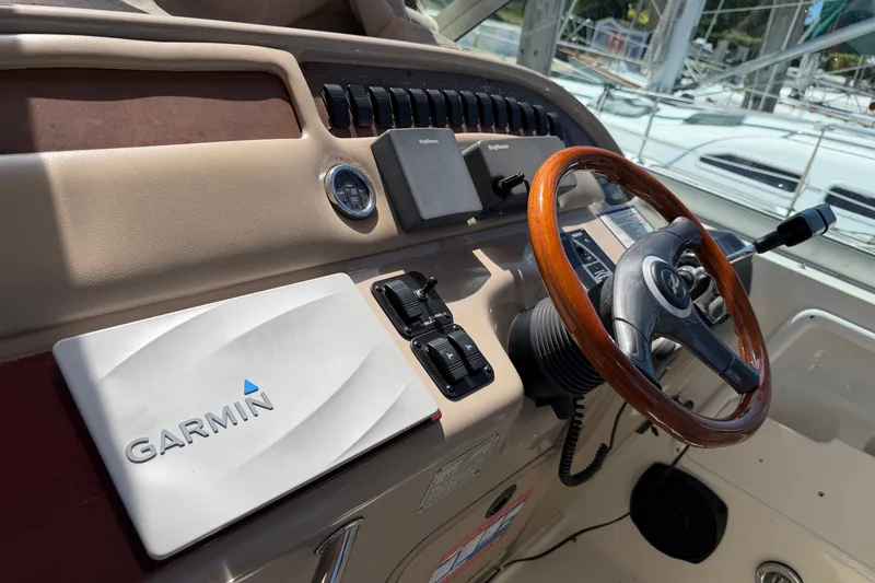 Slide: The Image of 1999 Sea Ray Sundancer 310 helm with Garmin navigation and wooden steering wheel. - 16