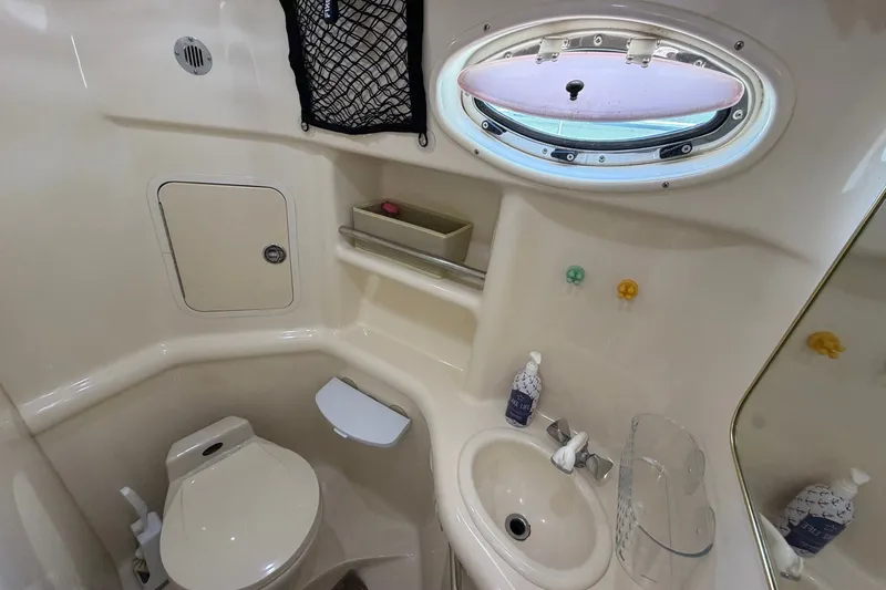 Slide: The Image of 1999 Sea Ray Sundancer 310 bathroom with toilet, sink, and porthole window. - 29