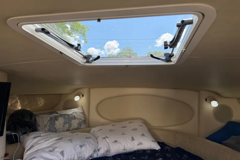 Slide: The Image of Interior cabin of 1999 Sea Ray Sundancer 310 with skylight and nautical-themed bedding. - 23