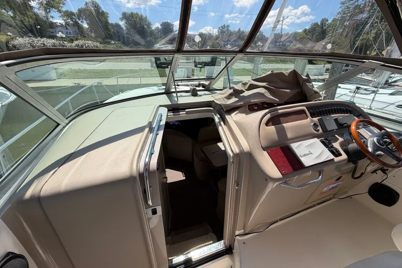 Slide: The Image of 1999 Sea Ray Sundancer 310 cockpit with steering wheel, navigation equipment, and cabin entrance. - 18