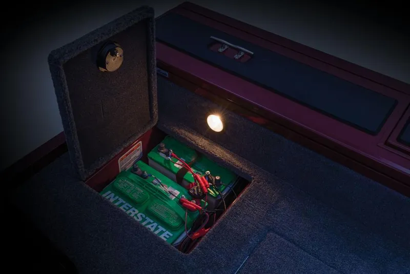 Slide: The Image of An open compartment in the boat reveals two green batteries with cables, illuminated by a small light. - 16