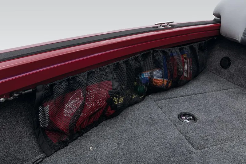 Slide: The Image of A mesh storage compartment on a Tracker Targa V-18 Combo boat, filled with various items. - 23