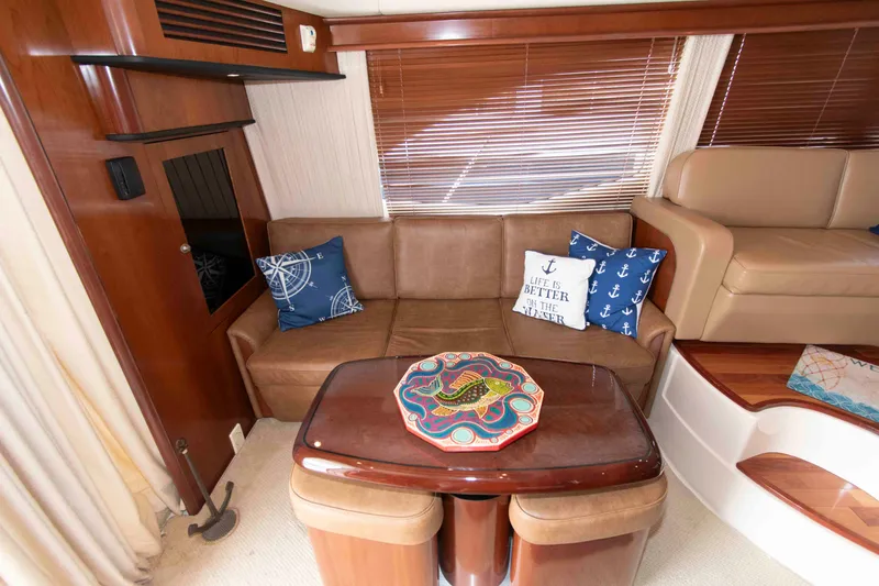 Slide: The Image of Luxurious 2006 Sea Ray 44 Sedan Bridge interior with cozy seating and nautical-themed decor. - 14