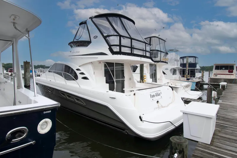 The Image of 2006 Sea Ray 44 Sedan Bridge yacht docked at marina under blue sky. - 0