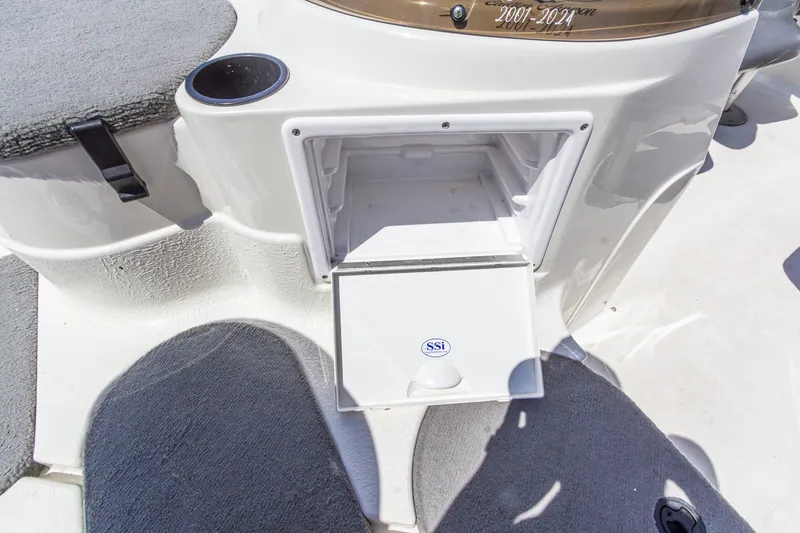 Slide: The Image of 2009 Yarcraft 1785 SC boat interior with open storage compartment and cup holder. - 24