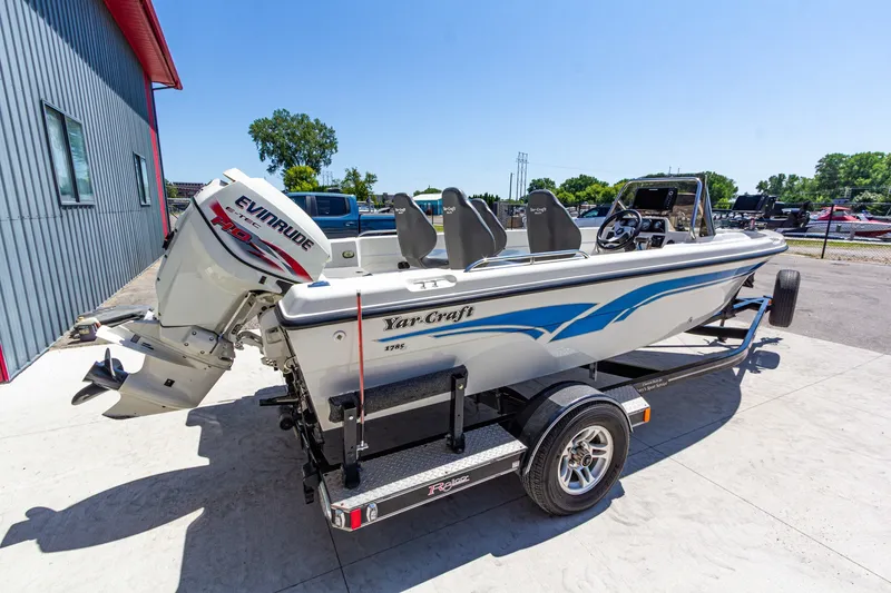 Slide: The Image of 2009 Yarcraft 1785 SC boat with Evinrude engine on trailer, parked outdoors. - 3