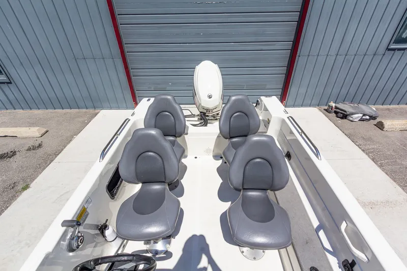 Slide: The Image of 2009 Yarcraft 1785 SC boat interior with four gray seats and outboard motor. - 16