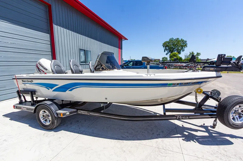The Image of 2009 Yarcraft 1785 SC boat on trailer, parked outside a building under clear blue sky. - 1