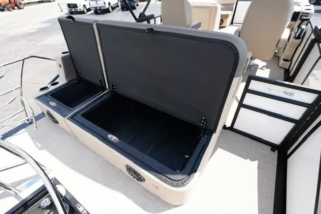 Slide: The Image of 2027 Harris Cruiser 210 SLDH boat with open storage compartments and beige seating. - 18