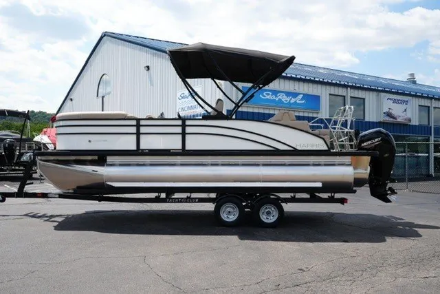 The Image of 2027 Harris Cruiser 210 SLDH pontoon boat on trailer, parked outside a dealership. - 1