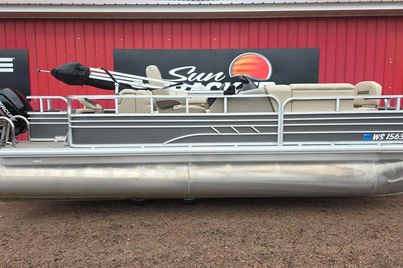 The Image of 2023 Sun Tracker Fishin' Barge 20 DLX pontoon boat displayed outdoors. - 0