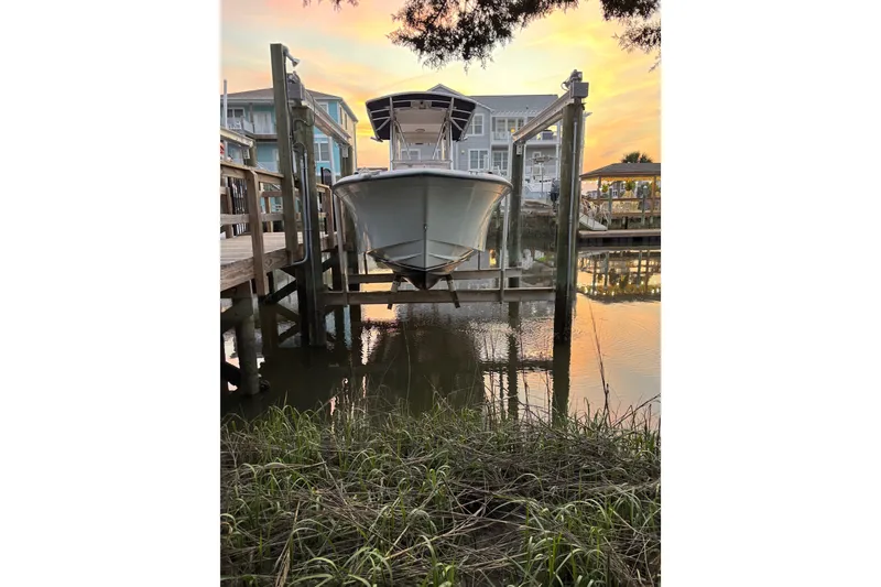 Slide: The Image of 2006 Grady-White Advance 257 boat docked at sunset, reflecting on calm water. - 2
