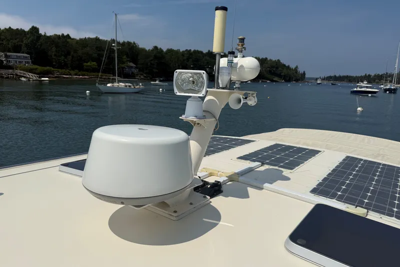 Slide: The Image of 2003 Ellis 36 Express Cruiser with radar and solar panels on a calm waterway. - 9