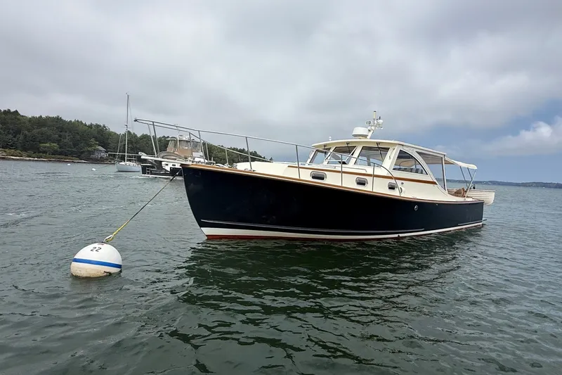 Slide: The Image of 2003 Ellis 36 Express Cruiser anchored on calm water with scenic background. - 1