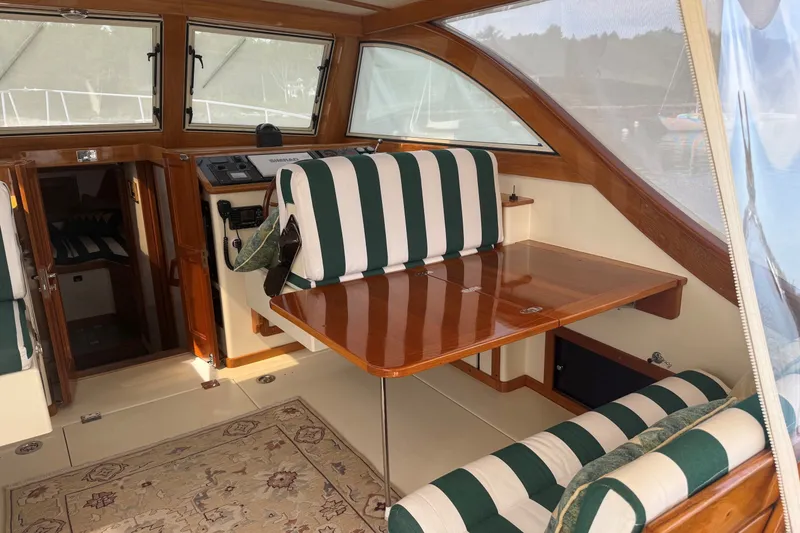 Slide: The Image of Interior of 2003 Ellis 36 Express Cruiser with striped seating and wooden table. - 37