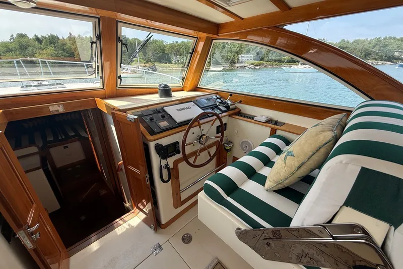 Slide: The Image of 2003 Ellis 36 Express Cruiser interior with striped seating and wooden helm. - 20