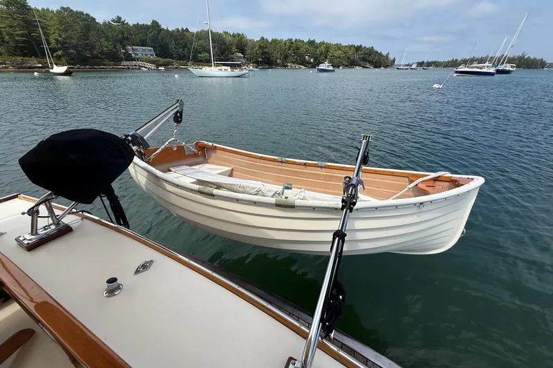 Slide: The Image of 2003 Ellis 36 Express Cruiser with dinghy on calm water, surrounded by sailboats. - 5