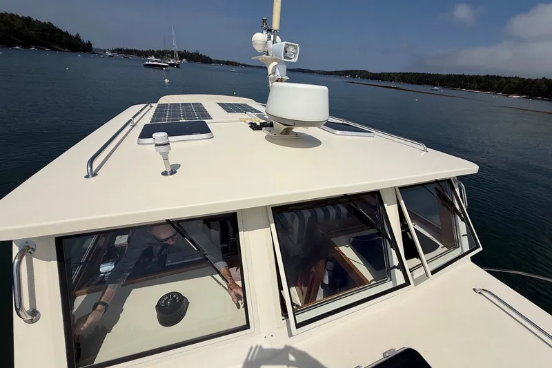 Slide: The Image of 2003 Ellis 36 Express Cruiser on calm waters with solar panels on deck. - 10