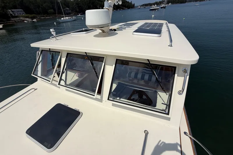 Slide: The Image of 2003 Ellis 36 Express Cruiser on calm water, featuring solar panels and sleek design. - 8