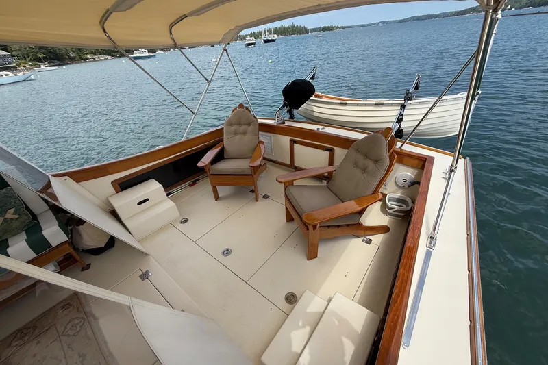Slide: The Image of 2003 Ellis 36 Express Cruiser deck with cushioned chairs, overlooking serene waters. - 15