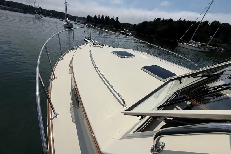 Slide: The Image of 2003 Ellis 36 Express Cruiser on calm water, showcasing sleek deck design and railing. - 11