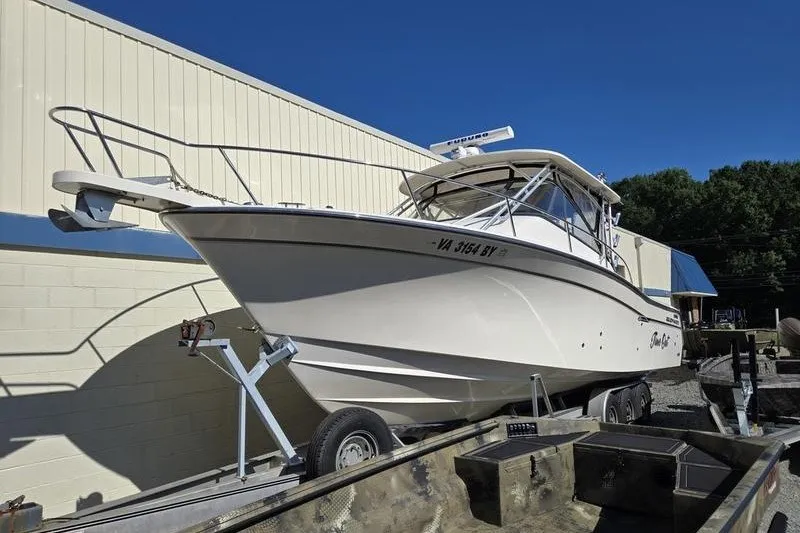 The Image of 2017 Grady-White Express 330 boat on trailer, parked outdoors under clear blue sky. - 1