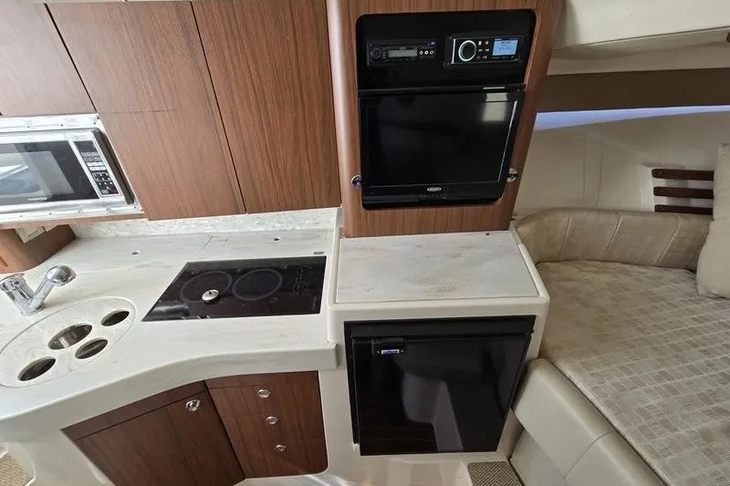 Slide: The Image of 2017 Grady-White Express 330 interior kitchen with stove, microwave, and compact fridge. - 15