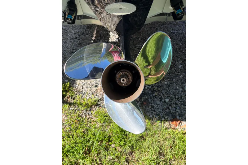 Slide: The Image of Chrome propeller of 2024 Highfield Sport 660 boat on gravel and grass background. - 19
