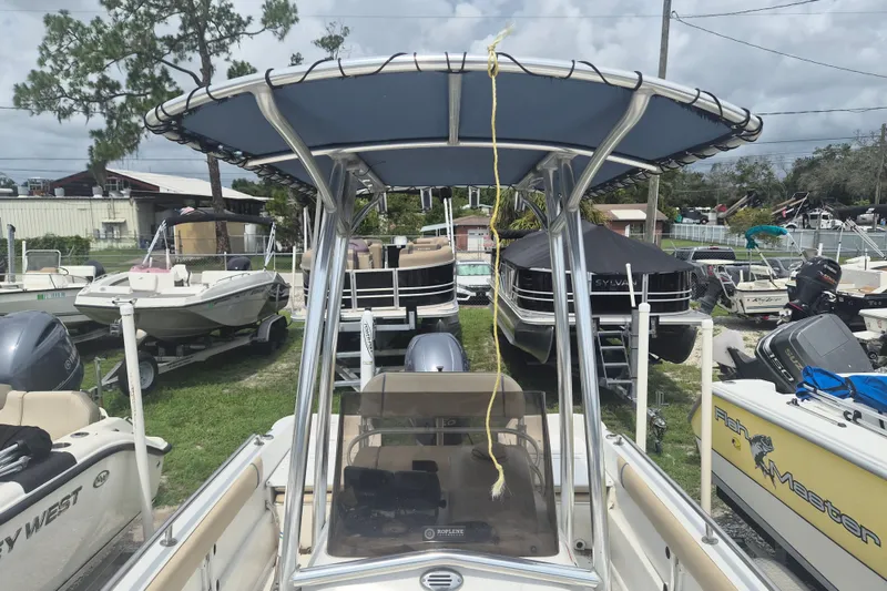 Slide: The Image of 2007 Triumph 190 Bay boat with T-top, parked among other boats in a marina. - 17