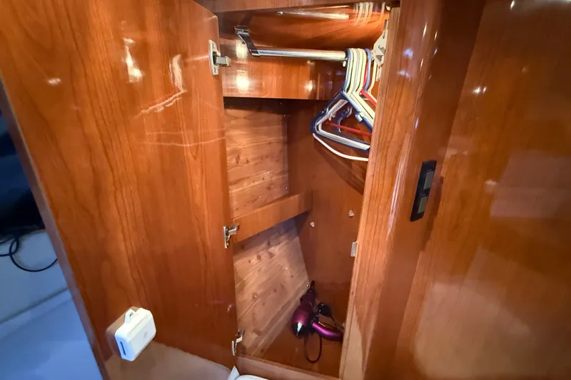 Slide: The Image of Wooden closet interior on 2005 Regal Commodore 3560 IO yacht with hangers and hairdryer. - 53