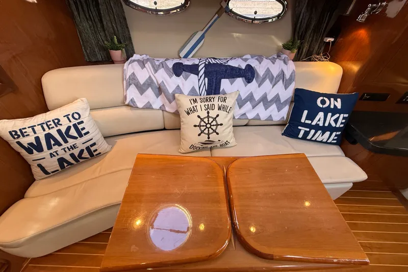 Slide: The Image of Interior of 2005 Regal Commodore 3560 IO with nautical-themed pillows and wooden table. - 35