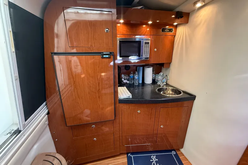 Slide: The Image of 2005 Regal Commodore 3560 IO yacht kitchen with wood cabinetry, microwave, and sink. - 39