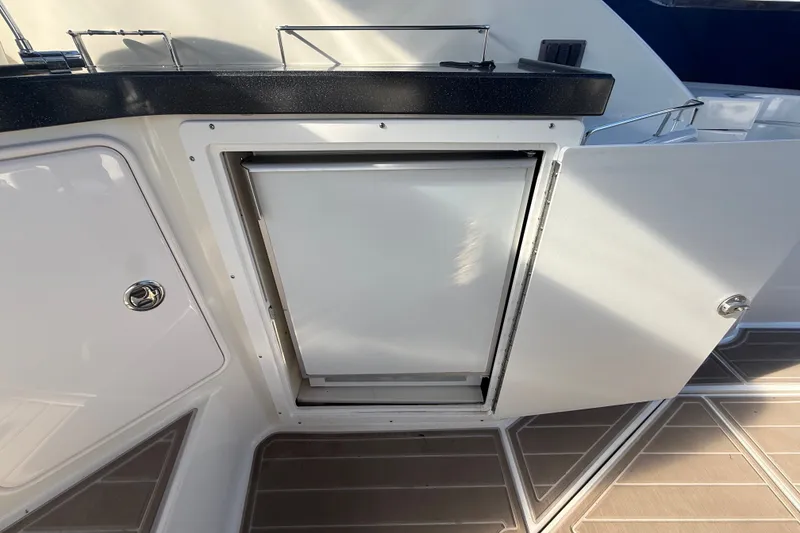 Slide: The Image of 2005 Regal Commodore 3560 IO boat interior with open cabinet and countertop. - 18