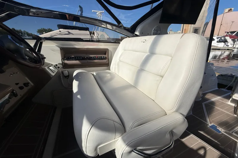 Slide: The Image of 2005 Regal Commodore 3560 IO boat interior with white leather seating and control panel. - 24
