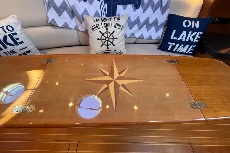 Slide: The Image of Interior of 2005 Regal Commodore 3560 IO with nautical-themed cushions and wooden table. - 36