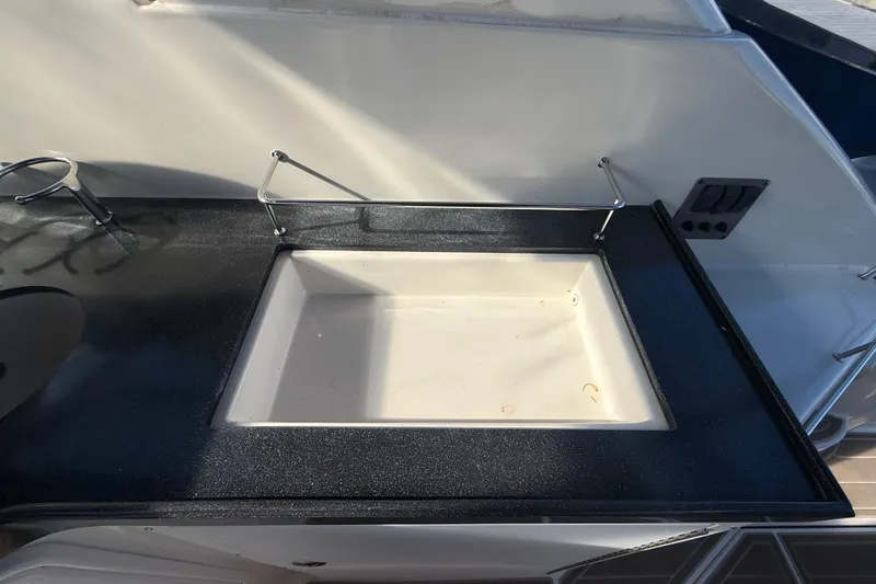 Slide: The Image of 2005 Regal Commodore 3560 IO boat sink with black countertop and faucet. - 17