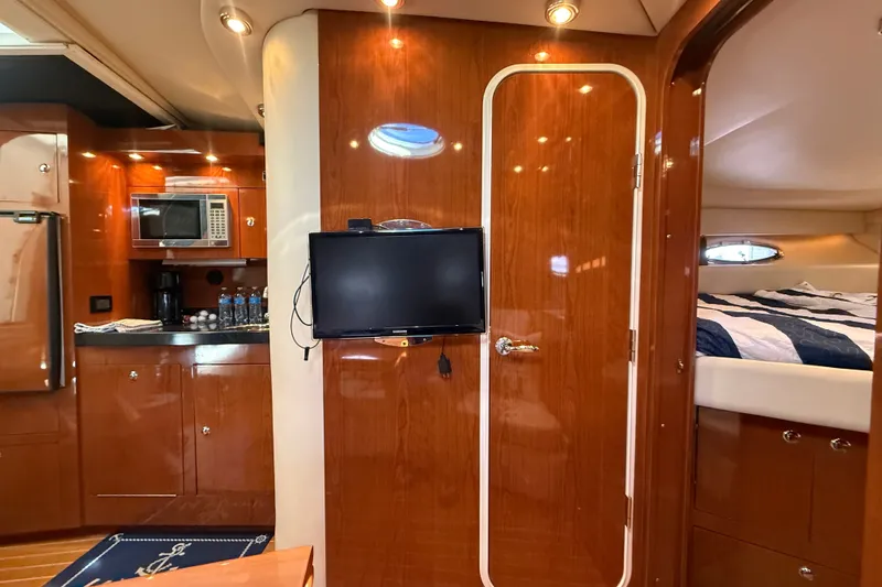 Slide: The Image of Luxurious 2005 Regal Commodore 3560 IO yacht interior with wood finish, kitchenette, and cozy sleeping area. - 47