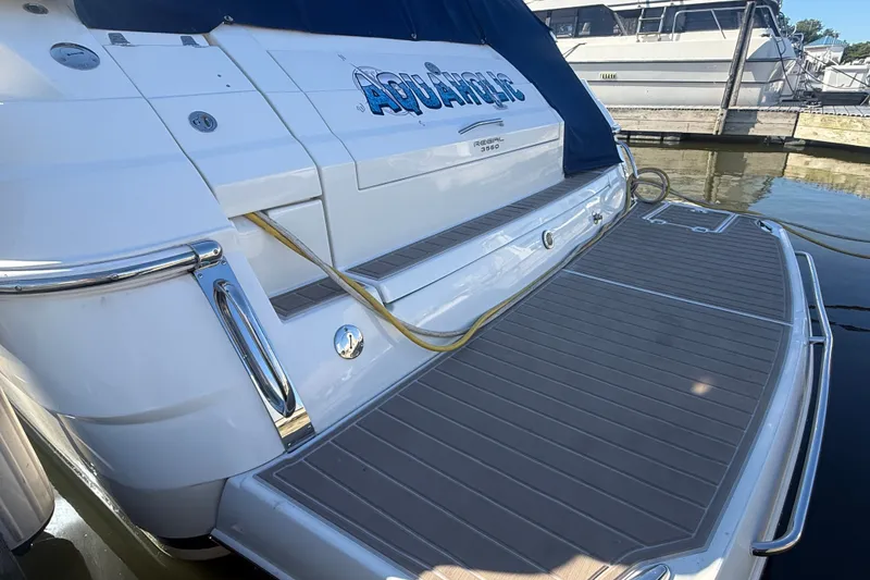 Slide: The Image of 2005 Regal Commodore 3560 IO yacht docked, featuring spacious deck and sleek design. - 3