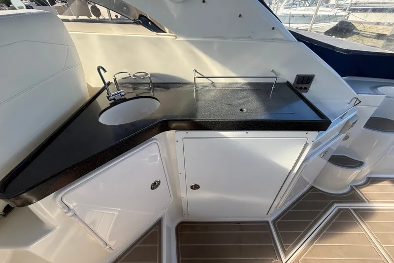 Slide: The Image of 2005 Regal Commodore 3560 IO yacht kitchenette with sink and storage cabinets. - 15