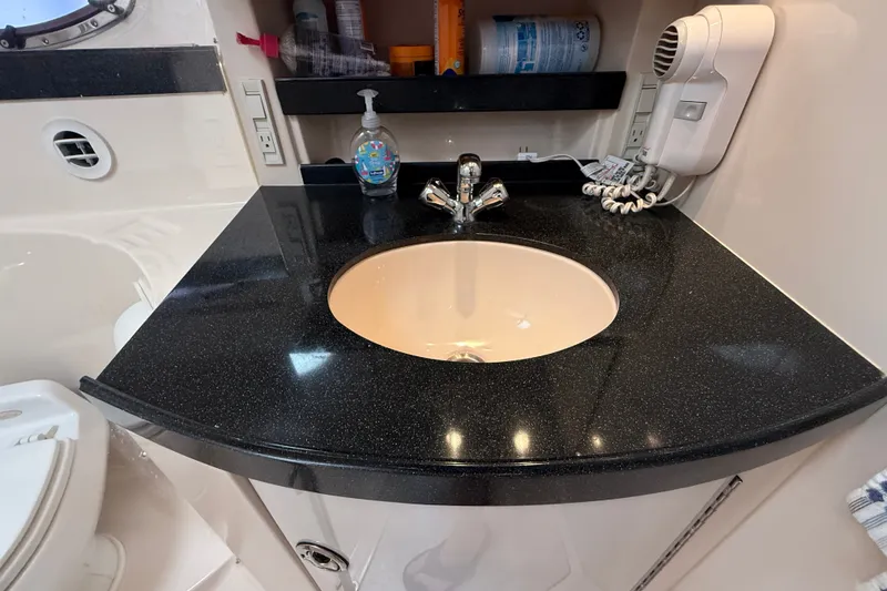Slide: The Image of 2005 Regal Commodore 3560 IO bathroom sink with black countertop and faucet. - 55