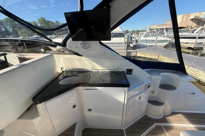 Slide: The Image of 2005 Regal Commodore 3560 IO yacht interior with kitchenette and mounted TV. - 14