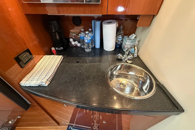 Slide: The Image of Compact galley area in a 2005 Regal Commodore 3560 IO yacht with sink and countertop essentials. - 42