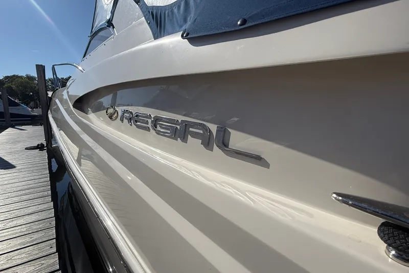 Slide: The Image of 2005 Regal Commodore 3560 IO boat docked, showcasing sleek design and branding. - 4