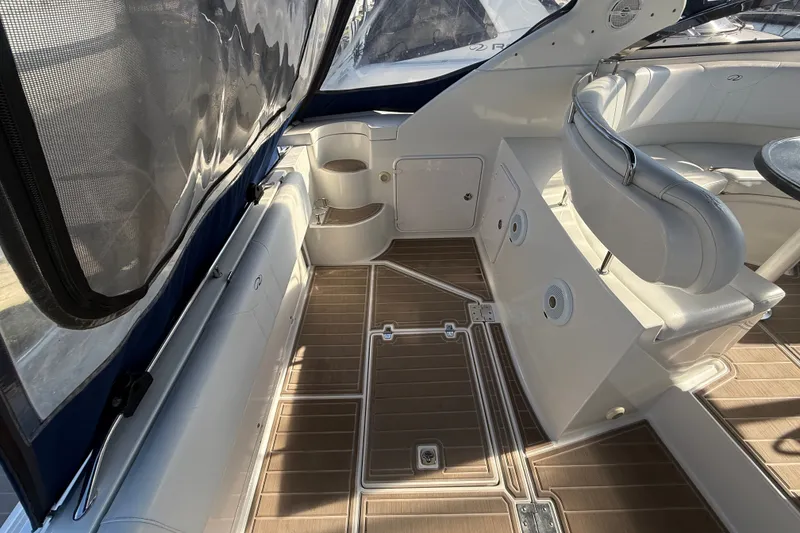 Slide: The Image of 2005 Regal Commodore 3560 IO boat interior with white seating and wood-patterned flooring. - 10